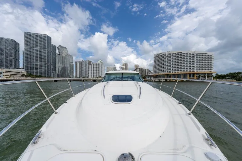  Yacht Photos Pics 2009 Sea Ray 43 Sundancer yacht cruising near city skyline under blue sky.