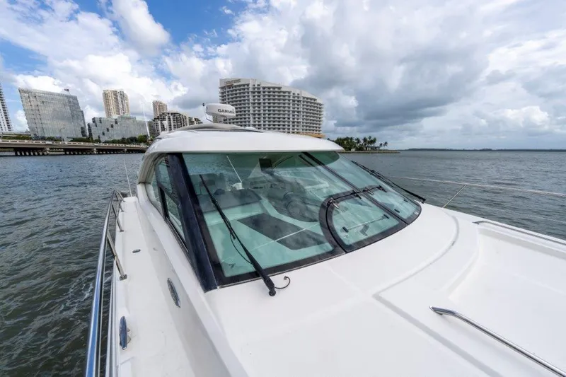  Yacht Photos Pics 2009 Sea Ray 43 Sundancer yacht cruising near city skyline under cloudy skies.
