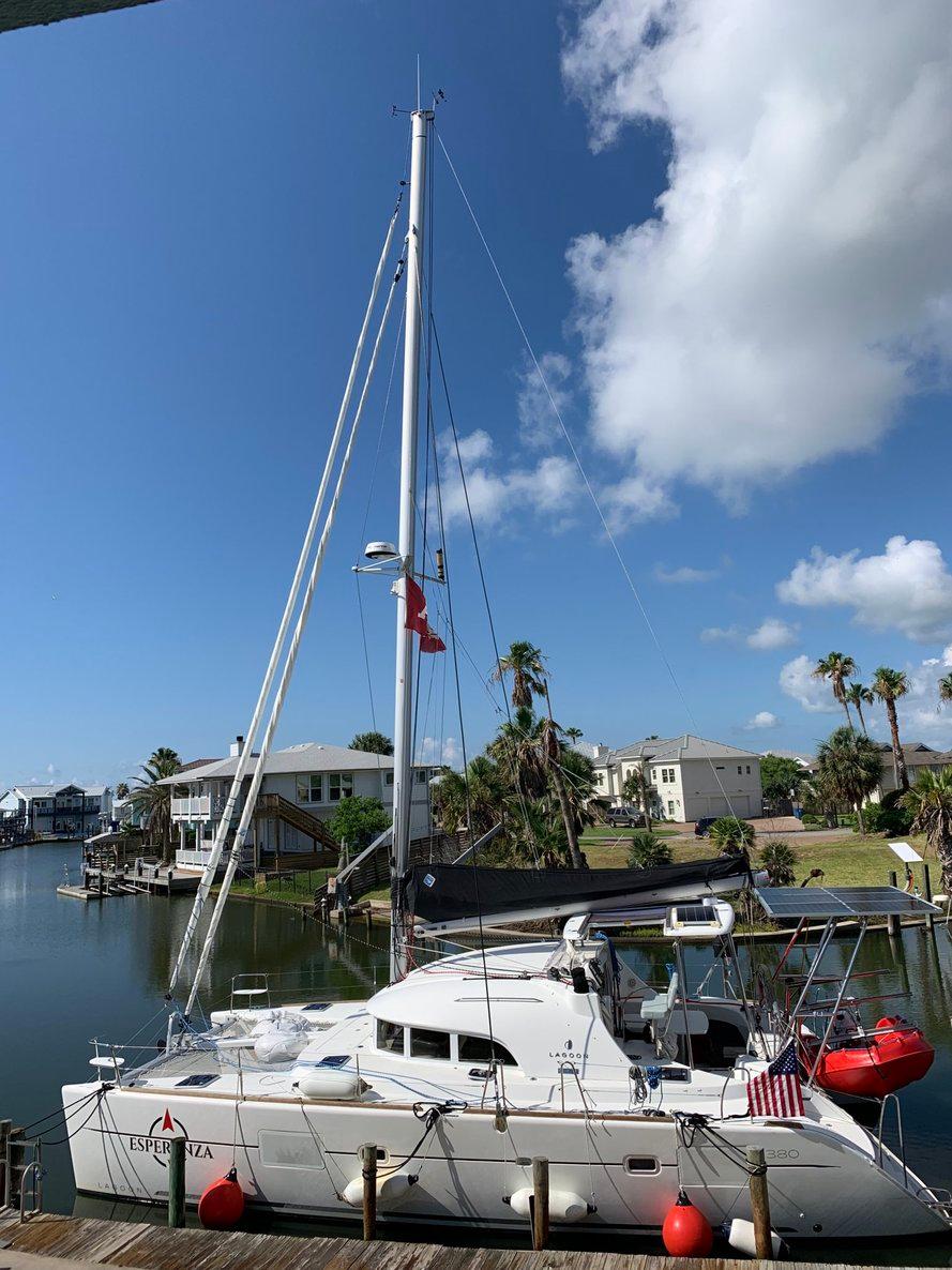 2019 Lagoon 380 S2 4/2 catamaran docked in a scenic waterfront area.