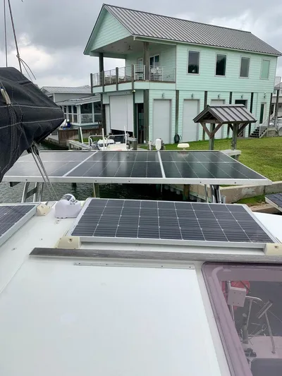 Esperanza Yacht Photos Pics 2019 Lagoon 380 S2 4/2 catamaran with solar panels, docked near a modern house.