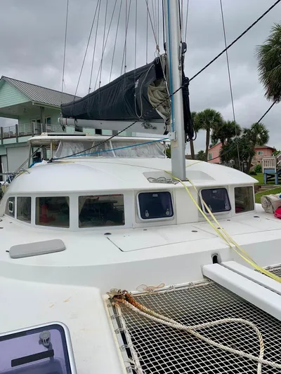 Esperanza Yacht Photos Pics 2019 Lagoon 380 S2 4/2 catamaran docked, featuring sails and netting, under cloudy skies.