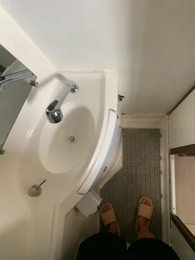 Esperanza Yacht Photos Pics Compact bathroom in 2019 Lagoon 380 S2 4/2 catamaran with sink and carpeted floor.