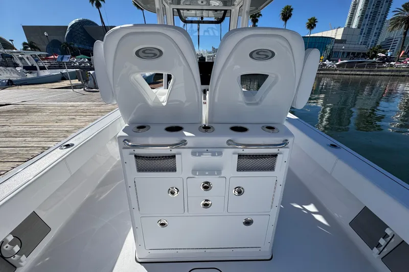  Yacht Photos Pics 2025 Sportsman Masters 267OE Bay Boat interior with dual seats and storage, docked by waterfront.