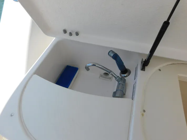 Cap & Dan Yacht Photos Pics Tiara Yachts 3800 Open 2001 sink with faucet and storage compartment.