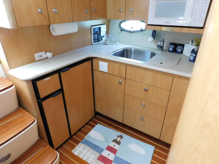 Cap & Dan Yacht Photos Pics 2001 Tiara Yachts 3800 Open galley with wood cabinets, sink, and appliances.