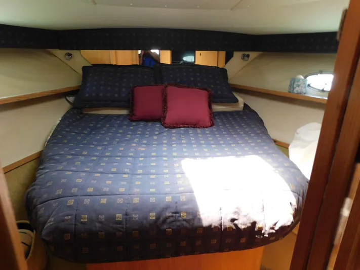Cap & Dan Yacht Photos Pics Cozy cabin interior of 2001 Tiara Yachts 3800 Open with a neatly made bed.