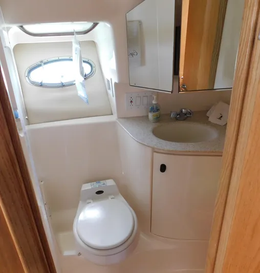 Cap & Dan Yacht Photos Pics 2001 Tiara Yachts 3800 Open bathroom with toilet, sink, and porthole window.