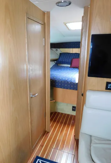 Cap & Dan Yacht Photos Pics 2001 Tiara Yachts 3800 Open cabin interior with bed, wood paneling, and seating.