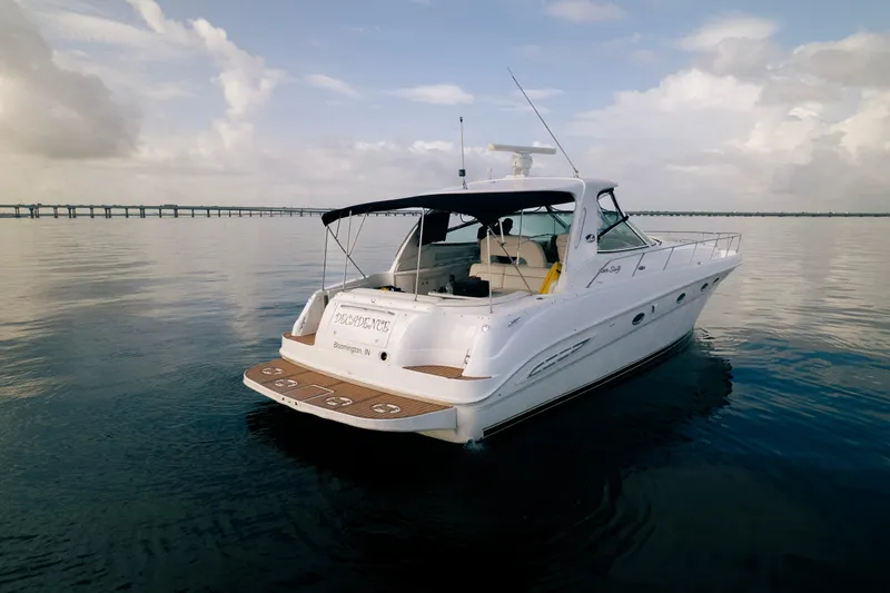 Decadance Yacht Photos Pics 2003 Sea Ray 460 Sundancer yacht on calm water under a cloudy sky.