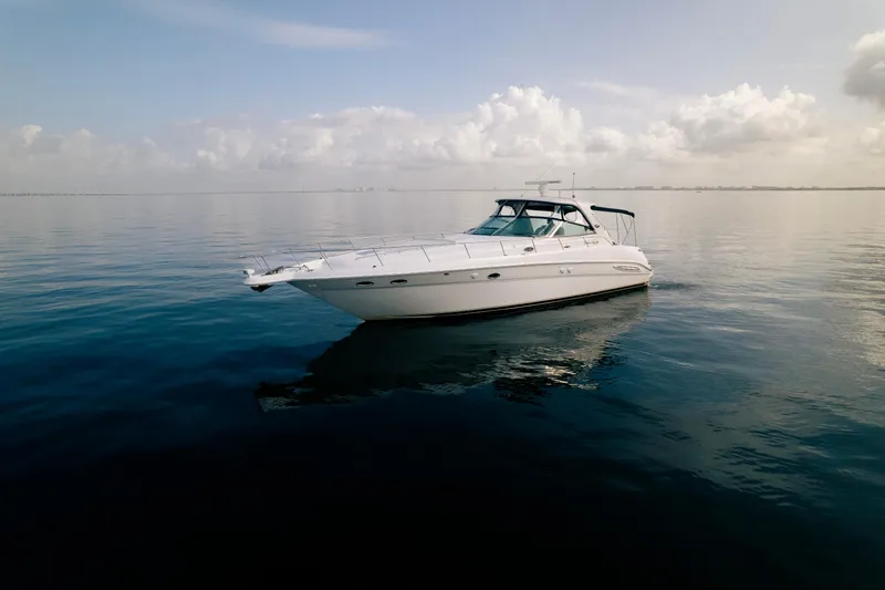 Decadance Yacht Photos Pics 2003 Sea Ray 460 Sundancer yacht on calm ocean waters under a cloudy sky.