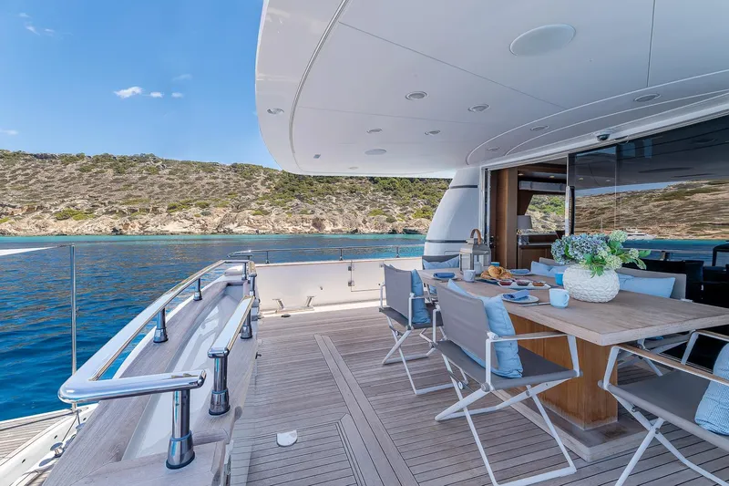 Easy Yacht Photos Pics Luxurious Sanlorenzo 82 yacht deck with dining area, overlooking serene blue waters, 2009 model.