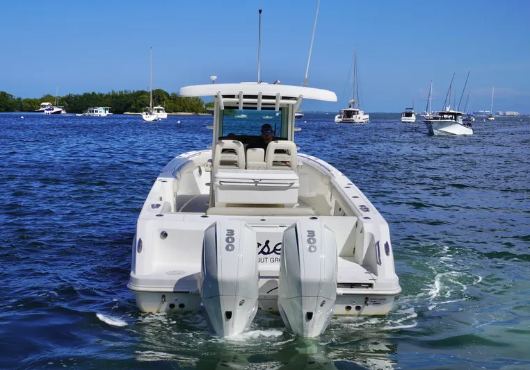 Vasea Yacht Photos Pics 2021 Boston Whaler 330 Outrage boat on water, rear view with twin engines.