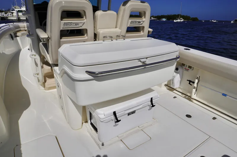 Vasea Yacht Photos Pics 2021 Boston Whaler 330 Outrage boat interior with seating and storage, docked by the water.