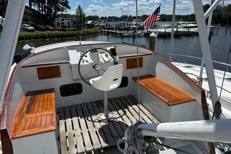  Yacht Photos Pics 1983 Kadey-Krogen Krogen 42 Trawler helm with wooden benches, docked by a marina.