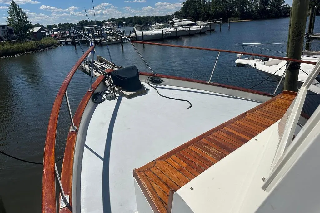 1983 Kadey-Krogen Krogen 42 Trawler docked, showcasing wooden deck and scenic marina view.