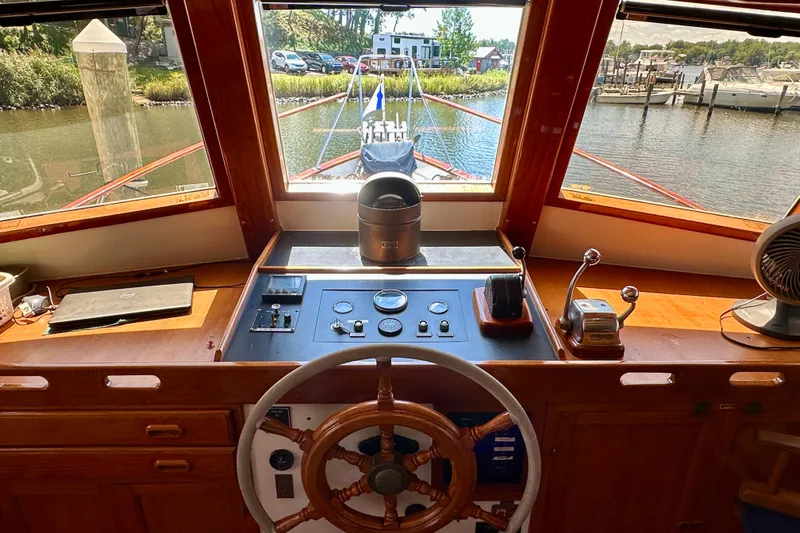  Yacht Photos Pics 1983 Kadey-Krogen Krogen 42 Trawler helm with wooden wheel and control panel, docked in marina.