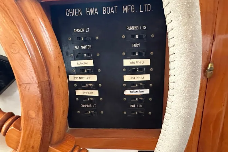  Yacht Photos Pics Control panel of 1983 Kadey-Krogen Krogen 42 Trawler with labeled switches and wooden wheel.