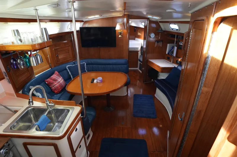 Summer Breeze Yacht Photos Pics Interior of a 2002 Catalina 42 Mark II sailboat with wood finish and blue seating.