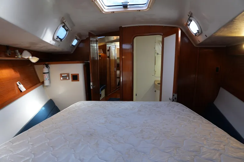Summer Breeze Yacht Photos Pics Interior cabin of 2002 Catalina 42 Mark II sailboat, featuring a cozy bed and wooden accents.