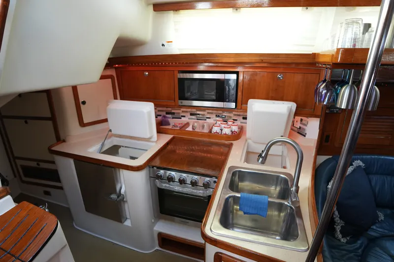 Summer Breeze Yacht Photos Pics Interior of 2002 Catalina 42 Mark II yacht kitchen with sink, stove, and microwave.