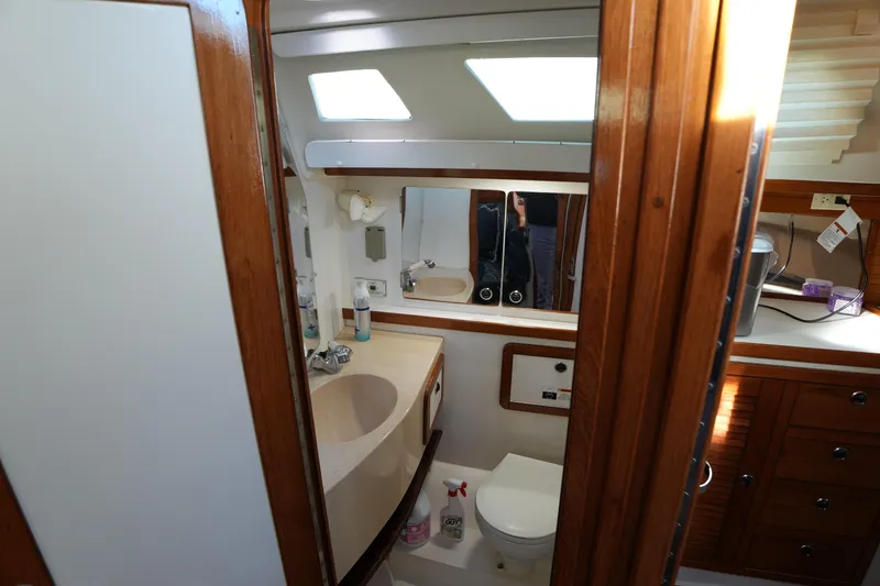 Summer Breeze Yacht Photos Pics Bathroom interior of 2002 Catalina 42 Mark II yacht, featuring wooden cabinetry and modern fixtures.