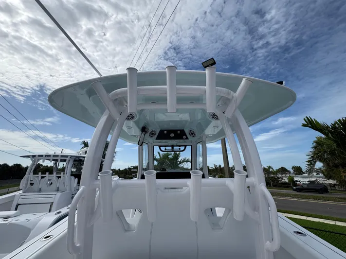  Yacht Photos Pics 2025 Sportsman Open 322 Center Console boat with rod holders, under a partly cloudy sky.