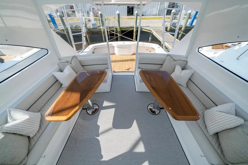 Pamela Yacht Photos Pics 2024 Viking 48 Sport Tower interior with elegant seating and wooden tables.