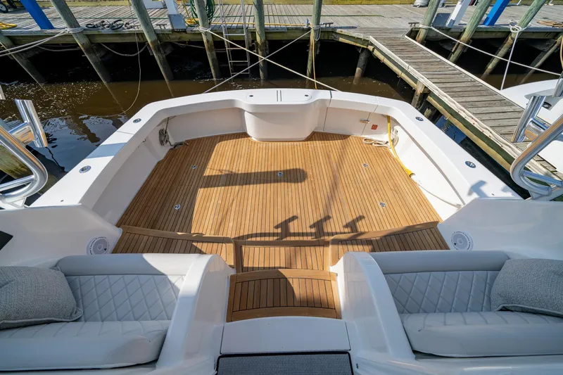 Pamela Yacht Photos Pics 2024 Viking 48 Sport Tower boat deck with teak flooring and cushioned seating.