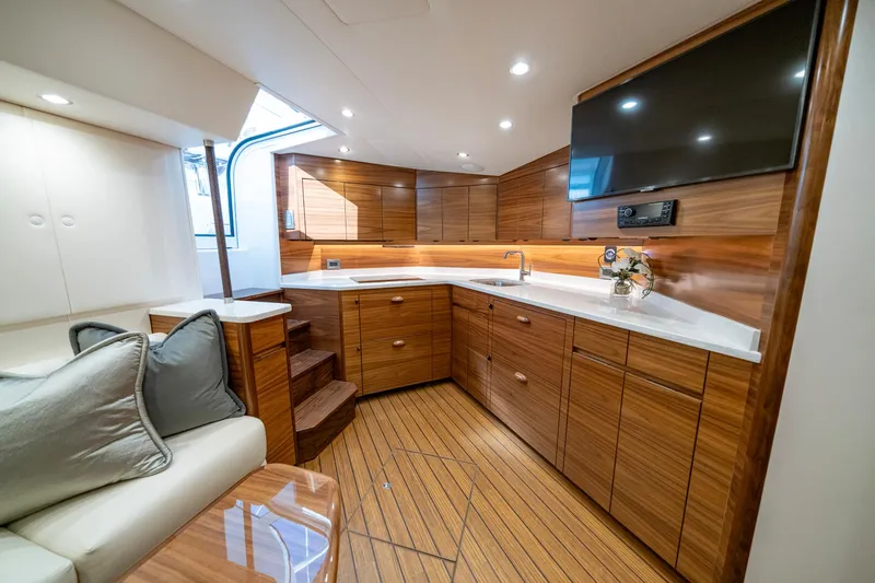 Pamela Yacht Photos Pics Luxurious interior of 2024 Viking 48 Sport Tower yacht with modern kitchen and seating area.