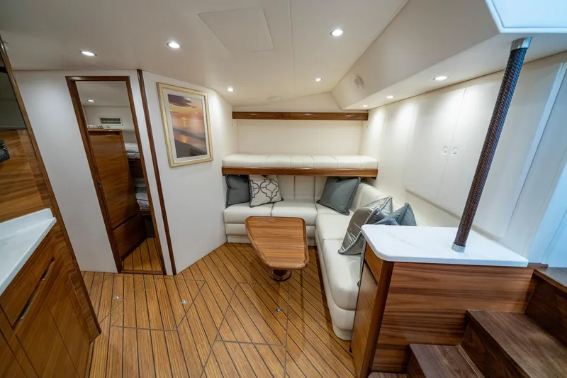 Pamela Yacht Photos Pics 2024 Viking 48 Sport Tower interior with elegant wood flooring and cozy seating area.