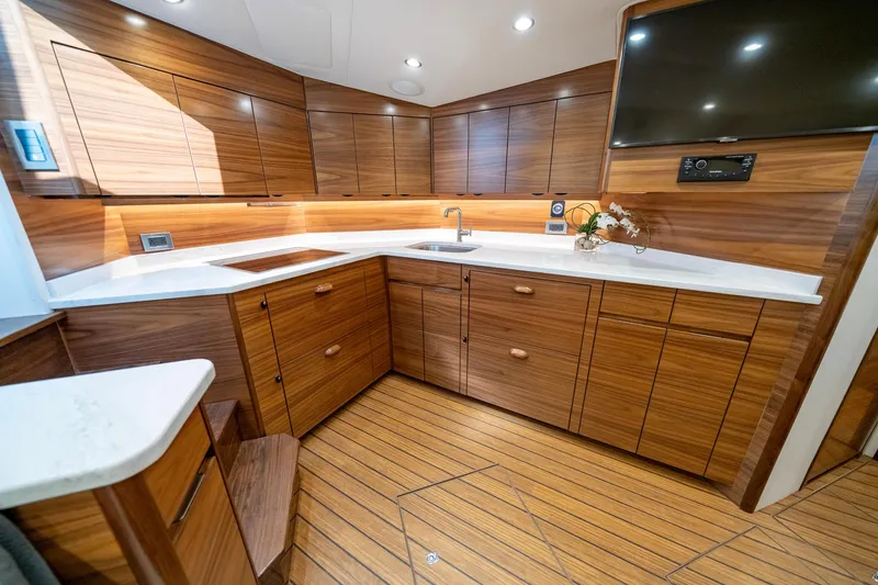 Pamela Yacht Photos Pics 2024 Viking 48 Sport Tower kitchen with wood cabinetry, modern appliances, and sleek design.