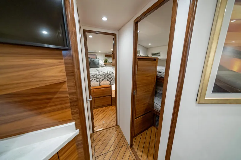 Pamela Yacht Photos Pics 2024 Viking 48 Sport Tower interior with wood finish and cozy bedroom.
