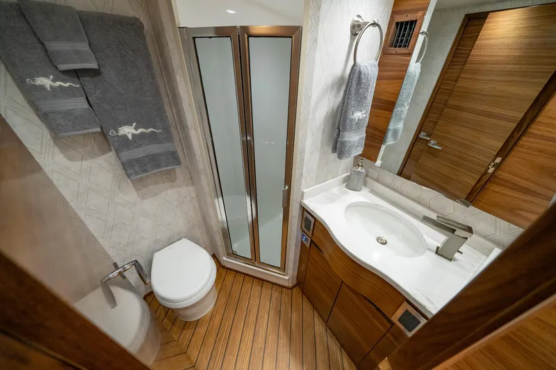 Pamela Yacht Photos Pics Luxurious bathroom in 2024 Viking 48 Sport Tower yacht with modern fixtures and wood accents.