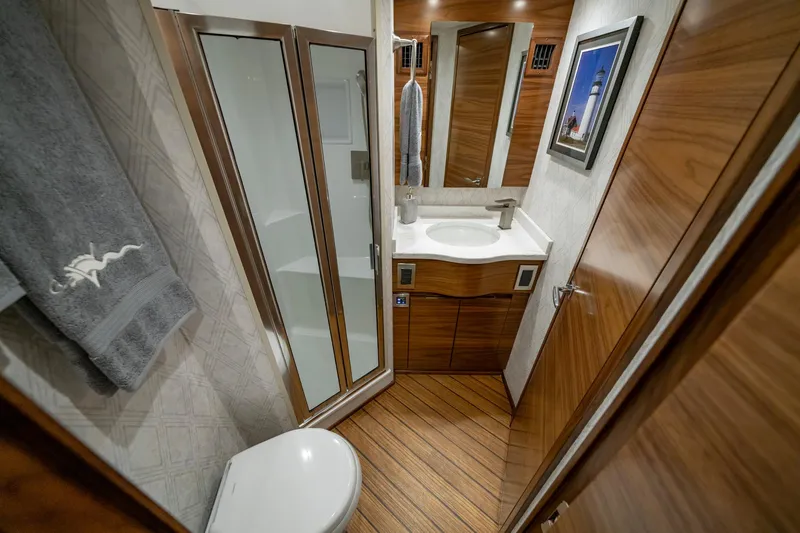 Pamela Yacht Photos Pics Luxurious bathroom in 2024 Viking 48 Sport Tower yacht with modern fixtures and wood accents.