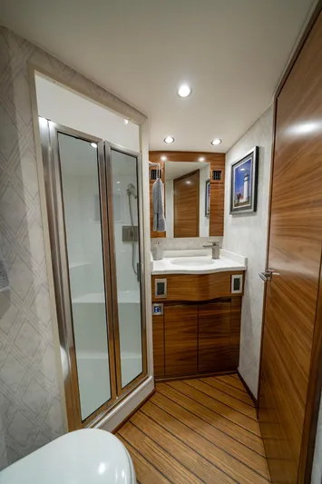 Pamela Yacht Photos Pics Luxurious bathroom interior of 2024 Viking 48 Sport Tower yacht with modern fixtures and wood accents.