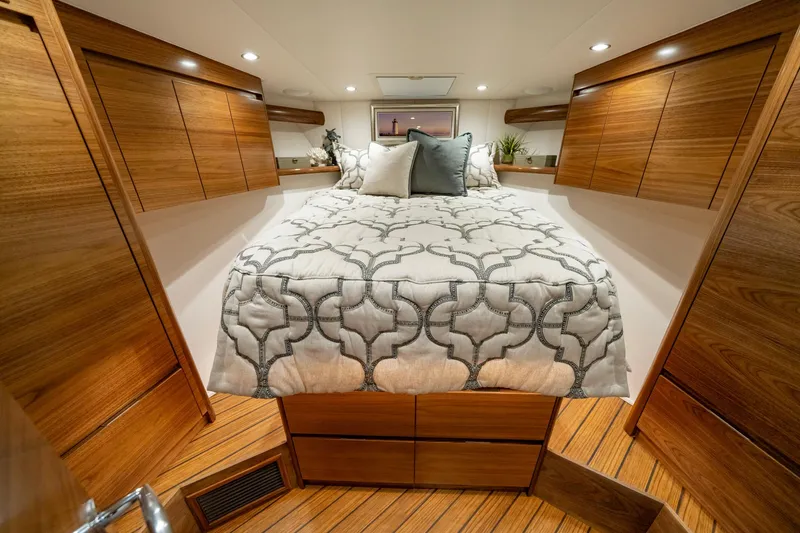 Pamela Yacht Photos Pics 2024 Viking 48 Sport Tower cabin with elegant wood finish and cozy bedding.