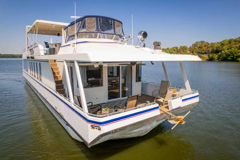  Yacht Photos Pics 2004 Stardust Cruisers houseboat on a serene lake, featuring spacious deck and modern amenities.