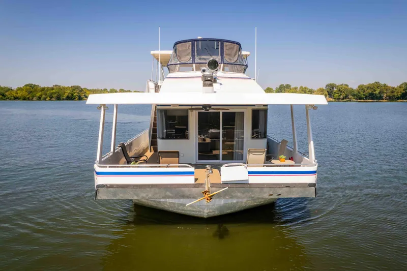  Yacht Photos Pics 2004 Stardust Cruisers houseboat on calm lake with clear blue sky.