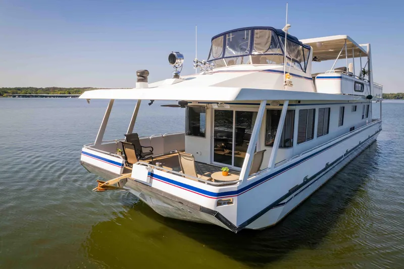  Yacht Photos Pics 2004 Stardust Cruisers houseboat on calm water, featuring spacious deck and modern design.