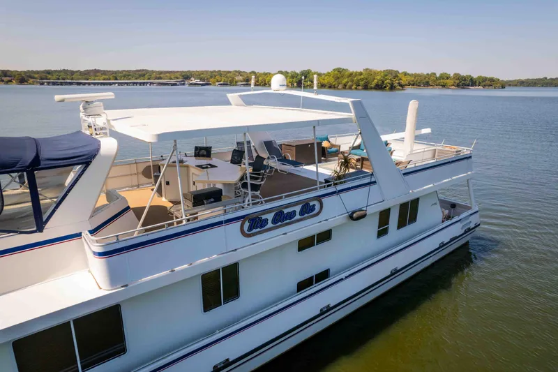  Yacht Photos Pics 2004 Stardust Cruisers houseboat on a serene lake with spacious deck and seating area.
