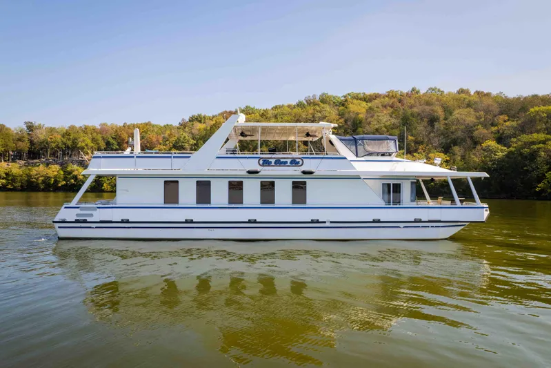  Yacht Photos Pics 2004 Stardust Cruisers houseboat on a serene lake with lush forest backdrop.
