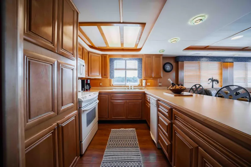  Yacht Photos Pics Luxurious 2004 Stardust Cruisers houseboat kitchen with wooden cabinets and modern appliances.