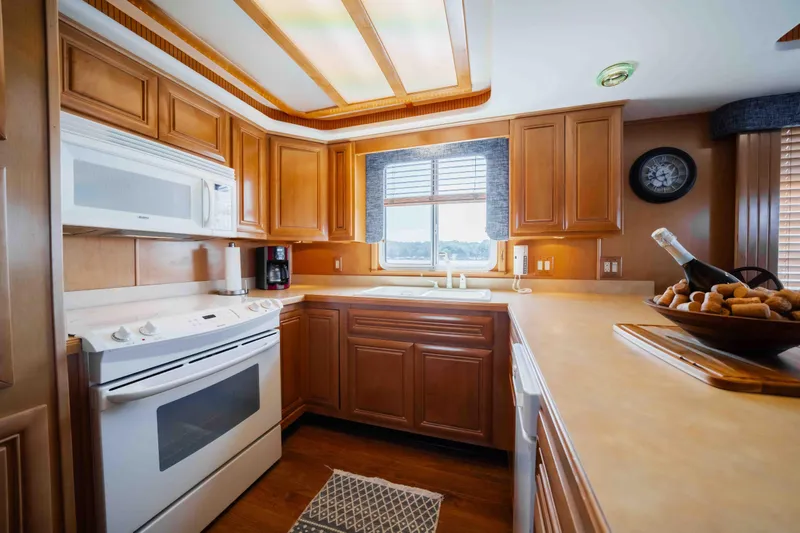  Yacht Photos Pics Luxurious 2004 Stardust Cruisers houseboat kitchen with wooden cabinets and modern appliances.