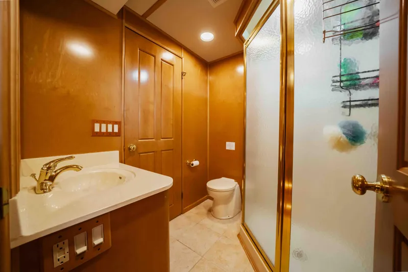  Yacht Photos Pics Luxurious 2004 Stardust Cruisers houseboat bathroom with wooden cabinetry and frosted glass shower.