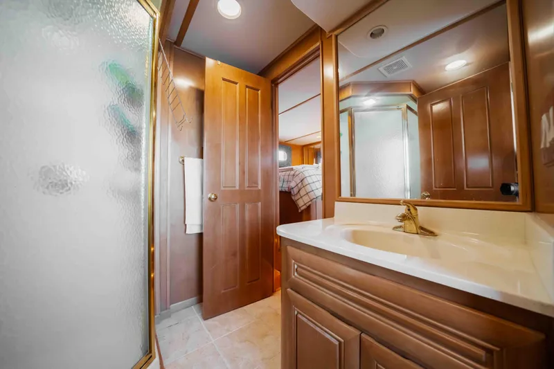  Yacht Photos Pics 2004 Stardust Cruisers houseboat bathroom with wooden cabinetry and glass shower.