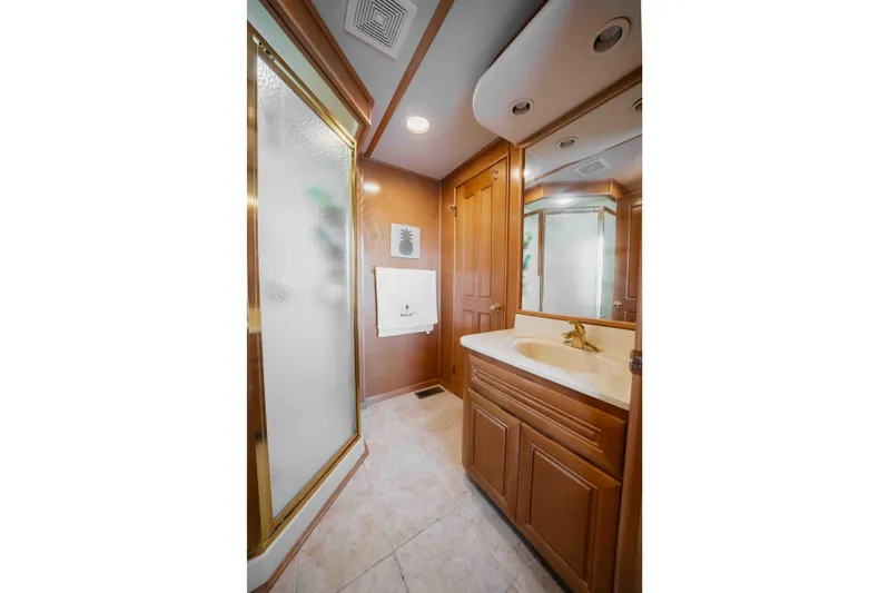  Yacht Photos Pics Luxurious 2004 Stardust Cruisers houseboat bathroom with wooden cabinetry and glass shower.