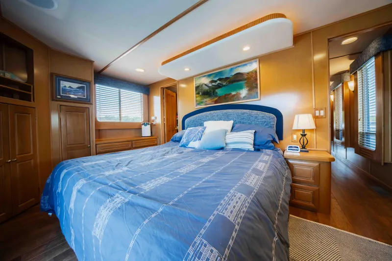  Yacht Photos Pics Luxurious 2004 Stardust Cruisers houseboat bedroom with blue bedding and elegant wood interior.