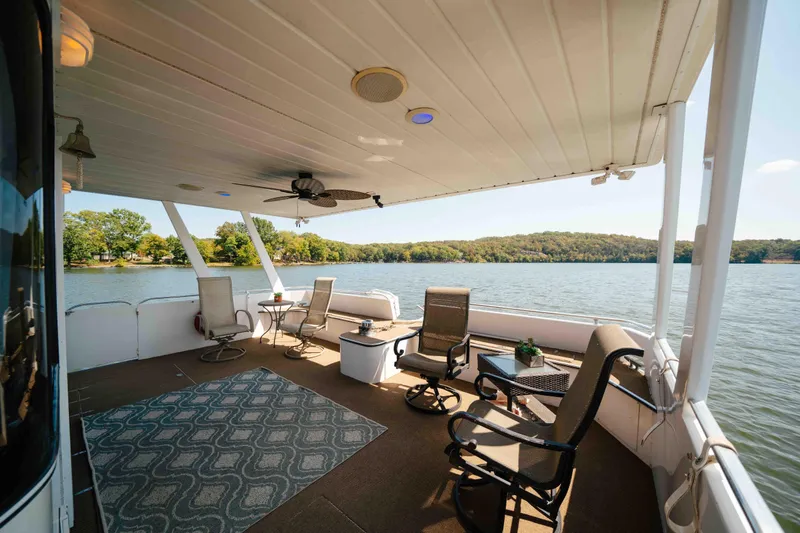  Yacht Photos Pics 2004 Stardust Cruisers houseboat deck with chairs, table, and scenic lake view.