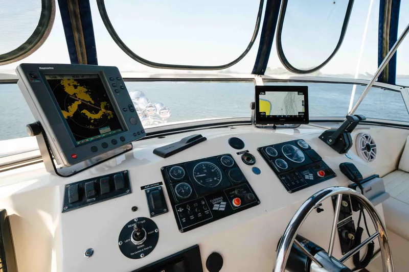  Yacht Photos Pics 2004 Stardust Cruisers houseboat helm with navigation equipment and steering wheel on open water.