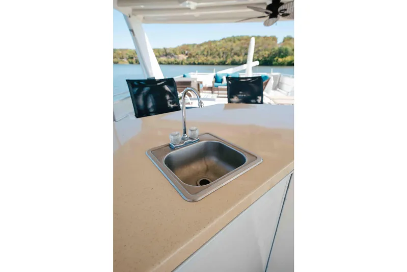  Yacht Photos Pics 2004 Stardust Cruisers houseboat kitchen sink with outdoor seating and scenic water view.